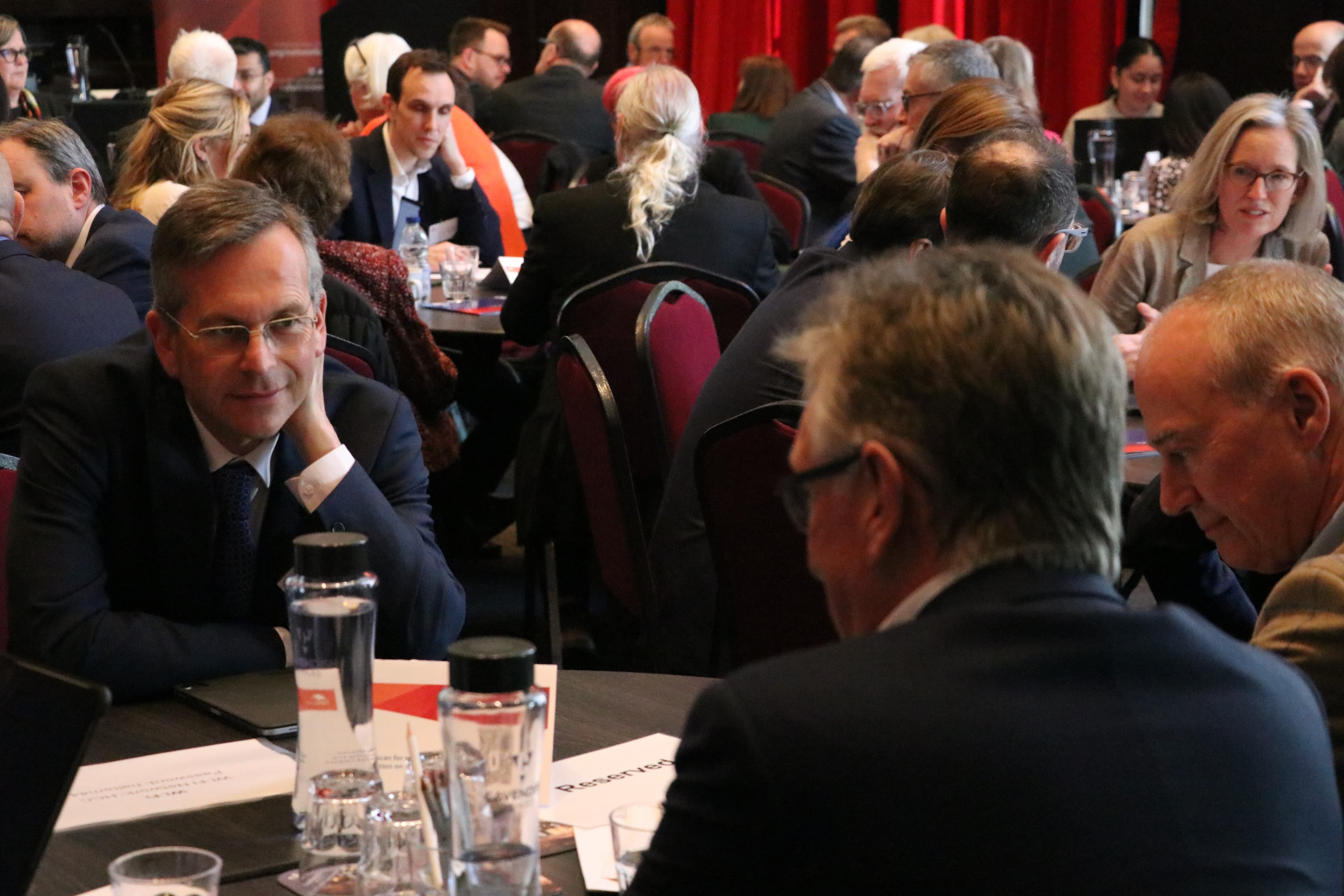 NHS trust leaders in discussion around tables at a NHS Providers network event.